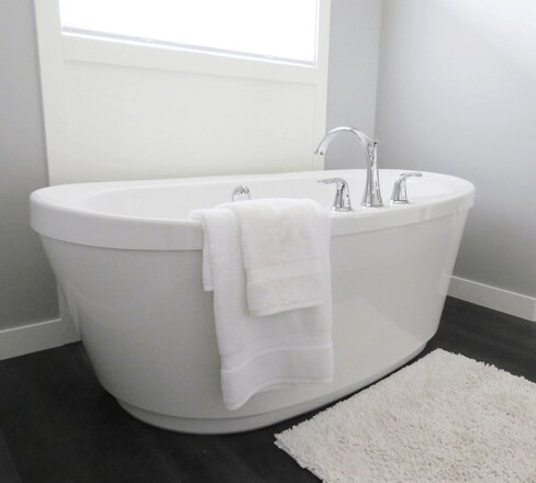 Freistehende Badewanne mit Handtuch in einem hellen Badezimmer